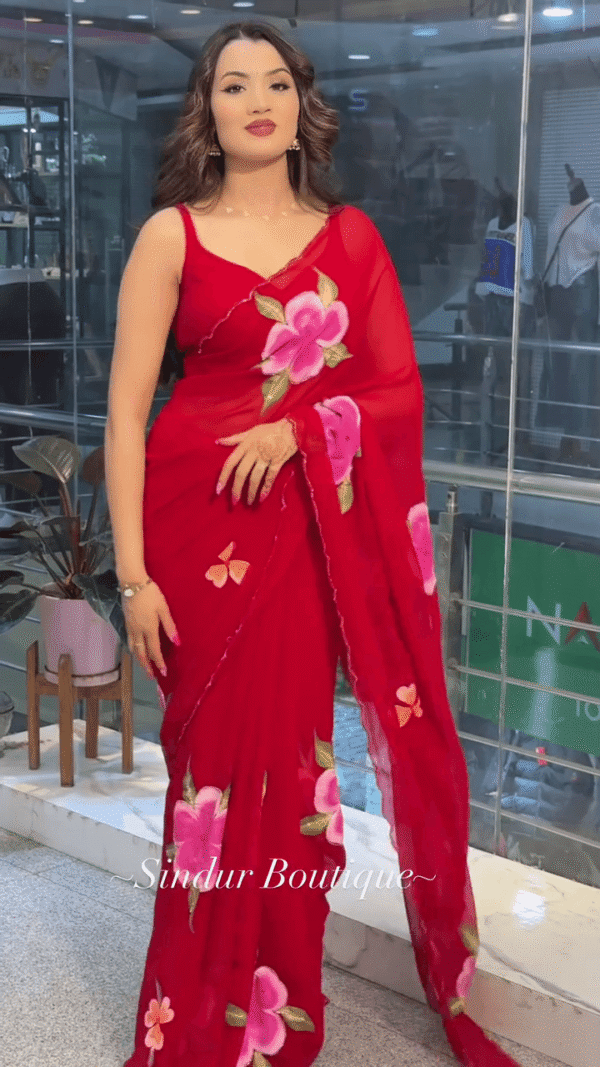 Red Georgette Saree with Hand-Painted Floral Design and Contrast Green-Pink Leaf Motifs, Paired with Matching Blouse and Delicate Border Detailing – Perfect for Festive and Traditional Wear